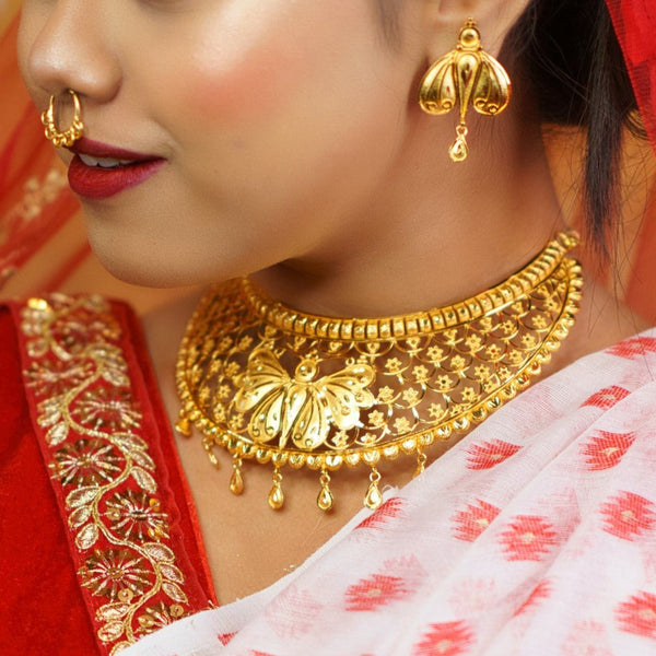 Gold plated butterfly charm bridal choker set and earrings worn by a woman in traditional attire.