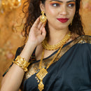 Stunning model wearing gold plated Bengali bridal earrings, necklace, and bracelet, showcasing traditional elegance.