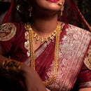 Bengali woman in traditional attire wearing a gold plated necklace and earrings showcasing a stunning wide U-shaped chatai set.