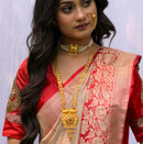 Bengali traditional woman wearing a gold plated necklace with matching earrings and red saree.